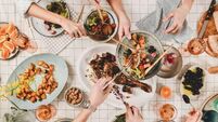 iStock-1148809207.jpg Peoples hands with various snacks and blooming mimosa, top view