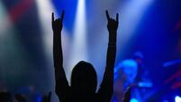 iStock-523688668.jpg Girl raising up hands on rock concert