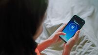 iStock-2169995660.jpg Asian woman using ai apps on bed