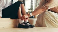 iStock-2189228444 shoes.jpg Hands, child and tie school shoes with mom from help, morning routine and people in home. Feet, getting ready and student with s