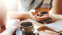 iStock-964487738.jpg Friends talking at cafe table during coffee break. Unrecognizable male and female colleagues discussing business issues, focus o