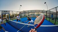 Padel_100_iStock-2266995181.jpg Friends playing padel on a blue outdoor court — energetic POV shot of group sport and recreation
