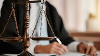 iStock-1643971176.jpg Closeup, scales and law on table, office and attorney man in blurred background with reading for crime analysis. Advocate, lawye
