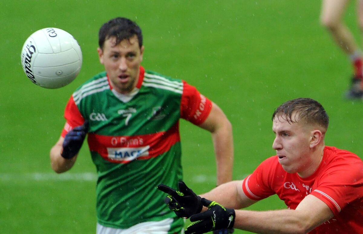 Blarney's David Lordan hand-passing the ball clear of John Barry of Fr O' Neill's. Picture Denis Minihane. Blarney's David Lordan hand-passing the ball clear of John Barry of Fr O' Neill's. Picture Denis Minihane.