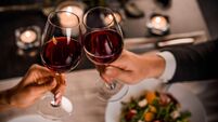 iStock-1184016689.jpg Close up of young couple toasting with glasses of red wine at restaurant